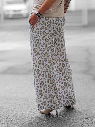 Nahaufnahme von OFF#DLY Pant Pisa Leo white/grey, getragen von einer Person. Die Hose zeigt einen lässigen Wide Leg Fit mit modernem Leo-Print und elastischem Bund, perfekt für warme Tage.