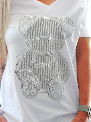 Nahaufnahme des OFF#DLY silver Bear V-Neck Shirts mit funkelndem Bären-Strass-Print, leichtem V-Ausschnitt und bequemem Schnitt, ideal als schulterfreies, lässig-feminines Mode-Statement.