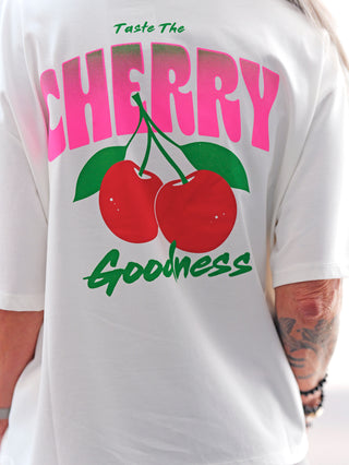 Nahaufnahme eines Arms mit dem OFF#DLY Tee Cherry offwhite, das durch ein auffälliges Kirsch-Design und einen abnehmbaren Cherry-Schlüsselanhänger besticht. Perfekt für einen lässigen Sommerlook.