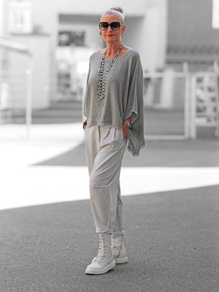 Nahaufnahme der OFF#DLY Hose Roma grey, die moderne Bundfalten und eine elegante Streifenstruktur zeigt. Die Hose fällt lässig und betont die Beine, ideal für stilvolle Outfits.