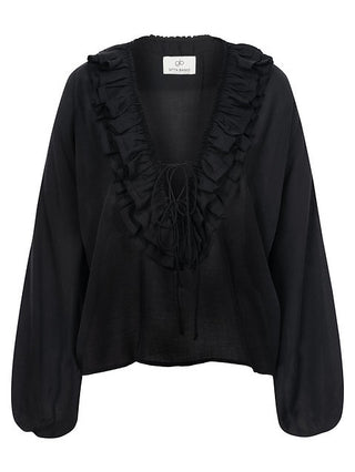 Gitta Banko Bluse Esmeralda black, eine schwarze Rüschenbluse mit Volants an Kragen, Knopfleiste und Ärmeln, aus 100% Tencel, präsentiert einen femininen, lockeren Schnitt.