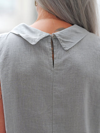 Nahaufnahme des oberen Rückens einer Person mit langem grauem Haar, die das OFF#DLY Blusenshirt Lavena lightgrey trägt, mit kleinem Peter-Pan-Kragen und Knopf am Nacken für einen femininen Look.