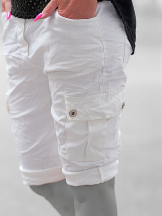 Nahaufnahme von OFF#DLY Short Lecce offwhite, getragen mit leicht gekrempeltem Saum und bequemen Cargotaschen. Hände in Fronttaschen, zeigt pinke Nägel, lässig und funktional für warme Tage.