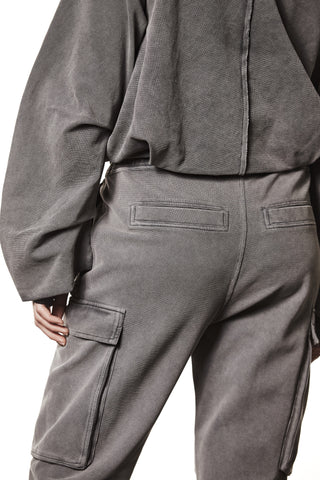 Thom Krom Jacket WSJ 494 used grey, Rückansicht, zeigt markante Seitentaschen und lässige Passform. Hand des Modells ruht an der Seite, passend zur monochromen Hose.