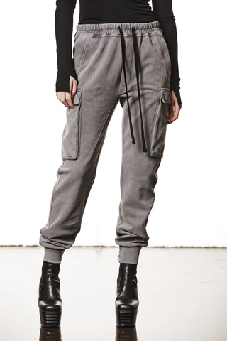 Thom Krom Pant WST 417 used grey, graue Jogger-Cargohose mit Oberschenkeltaschen und schwarzen hohen Plateau-Stiefeletten kombiniert, unterer Körper einer Person, die eng anliegendes schwarzes Langarmoberteil trägt.