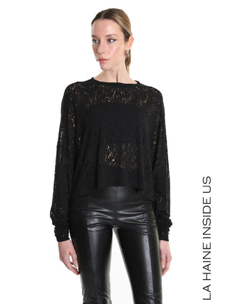 La Haine Sweater black LW5205: Model trägt locker geschnittenen, leicht transparenten schwarzen Pullover mit langen Ärmeln und Destroyed-Look, kombiniert mit hochtaillierten Lederhosen.
