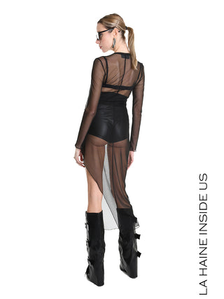 La Haine Dress black W5235: Schlanke Silhouette, transparentes Meshkleid mit langen Ärmeln, asymmetrischer Saum, hohe schwarze Stiefel; Modell trägt schwarze Shorts und BH darunter, Haare im niedrigen Pferdeschwanz.