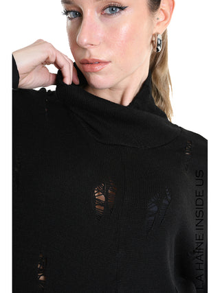 Junge Frau trägt La Haine Sweater LW5243 black, ein schwarzer Strickpullover mit hohem Kragen und Destroyed-Details, perfekt für edgy Looks. Sie trägt eine silberne Creole.