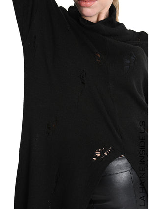 Person trägt La Haine Sweater LW5243 black, einen langen, schwarzen Strickpullover mit distressed Details und hohem Kragen, kombiniert mit schwarzen Lederoptik-Hosen. Perfektes urbanes Ensemble für edgy Looks.