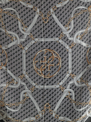 GUESS Noelle Scarf 130x130 BLA zeigt ein Kettengürtel-Design mit weißen Lederriemen und goldenen Ketten auf grauem Hintergrund, zentriert durch ein Medaillon mit ineinandergreifenden Goldringen und stilisierten Initialen.