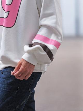 OFF#DLY Sweat NY white: Weißer Oversize-Sweater mit pinkem 9-Print, sportlichen Streifen an den Ärmeln. Kombiniert mit dunklen Jeans für urbanen City-Look.