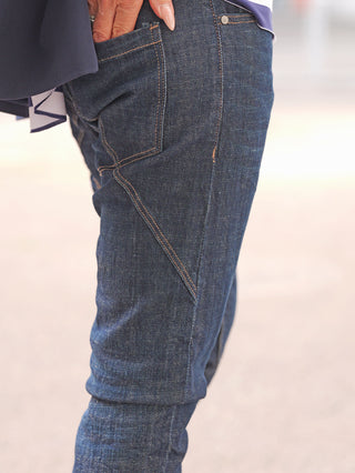 Nahaufnahme des unteren Torsos in OFF#DLY Denim Cremona Dark Denim Jeans, zeigt Kontrastnähte, seitliche Ziernähte und eine Hand in der Tasche. Perfekt für urbanen, stilvollen Look.
