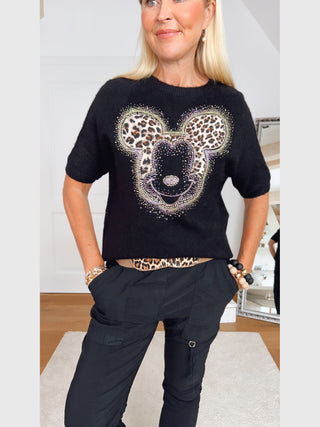 Person trägt den OFF#DLY Pulli Mickey black mit großem Mickey-Motiv in Leo-Print und funkelnden Strassdetails, kombiniert mit schwarzen Cargo-Hosen.