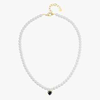 Die OFF#DLY Perlenkette Herz Anh. white black zeigt kleine, weiße Perlen mit einem goldenen Herzanhänger aus schwarzem Stein oder Emaille, verstellbarer Länge, und goldener Karabinerverschluss.
