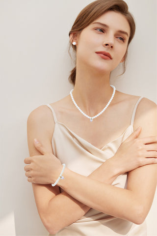Junge Frau trägt die OFF#DLY Perlenkette Herz Anh. white clear, eine choker-lange Perlenkette mit kleinem Herzanhänger, aus Edelstahl und Zirkon, kombiniert mit passendem Perlenarmband.