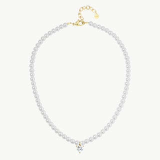 Die OFF#DLY Perlenkette Herz Anh. white clear zeigt kleine, runde weiße Perlen als Choker mit einem goldenen Karabinerverschluss und einem klaren, herzförmigen Kristallanhänger in einer goldenen Fassung.