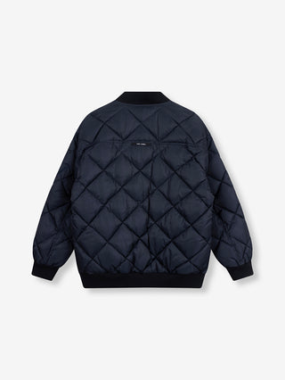 ALIX Quilted Bomber navy von hinten, zeigt eine navy-blaue, gesteppte Bomberjacke mit Rautenmuster, gerippten Bündchen und kleinem Etikett unterhalb der Schulterlinie. Oversize-Passform mit Reißverschluss und Fronttaschen.
