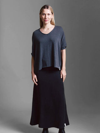 Frau trägt das Cotton Candy Tee Helay black melange, ein locker sitzendes, kurzärmeliges Oberteil mit V-Ausschnitt, kombiniert mit einem langen schwarzen Rock, minimalistischer Look.