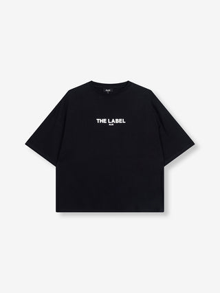 Schwarzes ALIX Basic The Label Tee mit boxy Schnitt, weißen „THE LABEL“-Schriftzug auf der Brust, kurzen Ärmeln und Rundhalsausschnitt aus schwerem Jersey. Entspannter, übergroßer Stil aus 100 % Baumwolle.