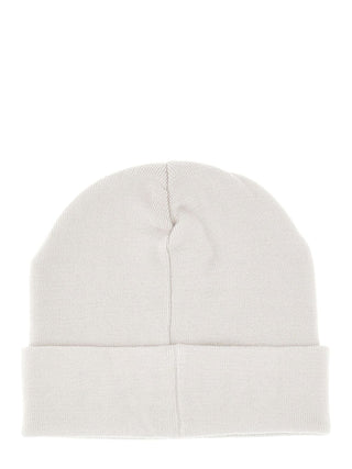 Guess Beanie GRY, eine schlichte Strickmütze mit Umschlag in neutralem Farbton, flach auf weißem Hintergrund liegend. Enthält ein dezentes Glitzer-Logo, ideal für den Winter. Material: 100 % Polyester.