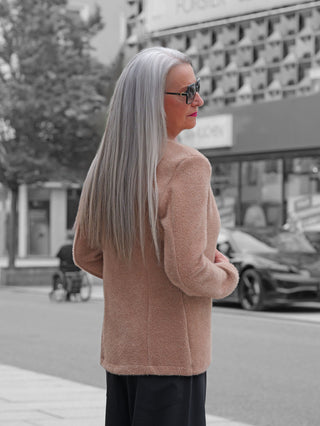 Ältere Frau in urbaner Umgebung trägt den OFF#DLY Blazer Sibilla camel mit leichtem Stehkragen und strukturierter Oberfläche, perfekt für vielseitige Outfits von casual bis chic.