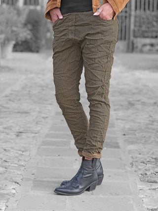 OFF#DLY Muster-Pant Saga camel: Elegante, gemusterte Hose mit schmalem Schnitt, getragen mit schwarzen Lederstiefeletten und warmbrauner Jacke. Ideal für stilvolle, bequeme Alltags- und Freizeitoutfits.