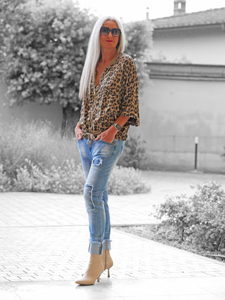 Frau trägt die OFF#DLY Leo Jacke Hedda camel mit lässigem Leo-Muster, kombiniert mit hellen Jeans und beigen Stiefeletten, vor einem neutralen Hintergrund.