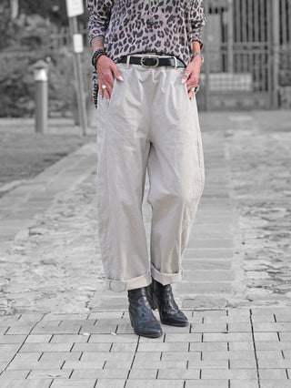 Die OFF#DLY Pant Melania stone zeigt sich in einem lässigen Schnitt, aus leichtem Stoff mit umgeschlagenen Knöcheln, kombiniert mit einem schwarzen Gürtel, ideal für vielseitige Outfits.