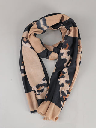 Der OFF#DLY Schal beige/black zeigt ein leichtes, weich fallendes Design mit warmem Beigeton, durchzogen von schwarzen Gittern und Leopardenmuster-Akzenten. Die Enden sind schlicht gesäumt.