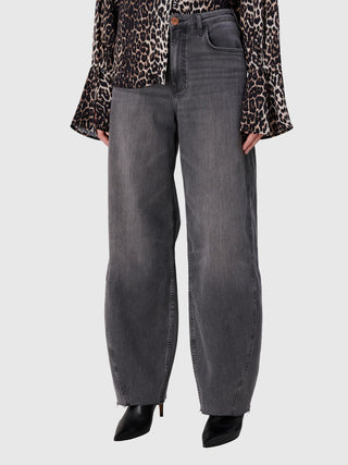True Religion Ruby Volume Jeans, hoch tailliert und weit geschnitten, mit offenem Saum und verdecktem Reißverschluss, kombiniert mit einer Leopardenbluse und schwarzen Stiefeletten.
