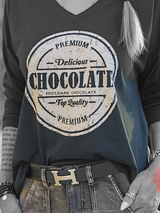 OFF#DLY Longsleeve Chocolate black: Schwarzes V-Ausschnitt-Shirt mit auffälligem, distressed Schokoladen-Logo-Print, kombiniert mit lässigem Schnitt, ideal für entspannte Outfits.