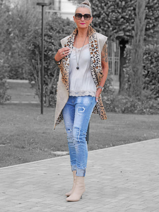 Frau trägt die OFF#DLY Denim Lara lightblue, eine leicht zerstörte, hellblaue, an den Knöcheln gekrempelte Jeans, kombiniert mit beigen Stiefeletten und einem trendigen, lässigen Look.