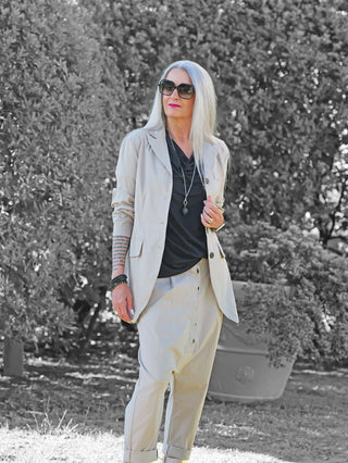 Person trägt den OFF#DLY Blazer Abigail Stone: ein leicht oversized, eleganter Blazer in hellem Beige, kombiniert mit einem schwarzen Top. Ideal für moderne, vielseitige Looks.