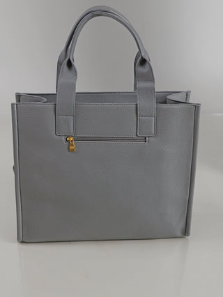 Enrico Coveri Shopper grey: Rechteckige, mittelgroße Tasche aus grauem, genarbtem Kunstleder mit zwei Henkeln, einer schlanken Fronttasche mit goldfarbenem Reißverschluss, auf einer glatten, hellen Oberfläche liegend.