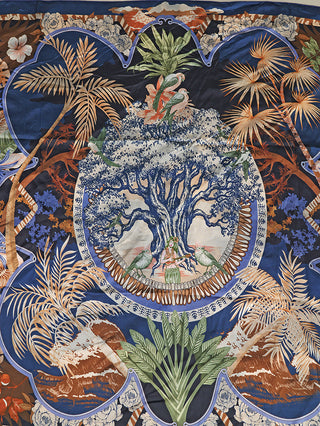 Das OFF#DLY Tuch Oak mit Spange blue zeigt ein reich verziertes, naturinspiriertes Medaillon-Motiv mit einem Baum, Vögeln und tropischen Blättern, ideal als Halstuch mit Clip.