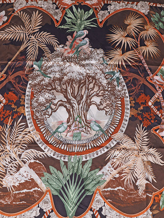OFF#DLY Tuch Oak mit Spange brown zeigt ein reich gemustertes Halstuch mit tropischem Baum- und Vogelmotiv, zentral eine Frau mit Saiteninstrument, dekorative Pflanzenmuster umrahmen das Design.