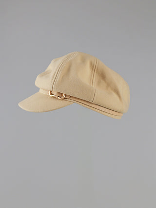 OFF#DLY Capello beige: Eine beige Baker-Boy-Mütze aus weichem, strukturiertem Stoff mit kurzem Schirm und passendem Band, das eine kleine goldfarbene Ringverzierung an der Seite aufweist.
