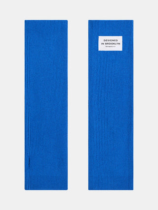 Penn & Ink Stulpen royalblue: Ein Paar leuchtend kobaltblaue Strick-Armstulpen mit Daumenloch. Eine Stulpe zeigt ein weißes Etikett DESIGNED IN BROOKLYN PENN&INK N.Y. am Bündchen.