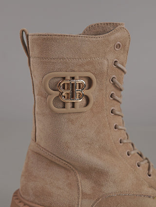 Nahaufnahme des OFF#DLY Boot BB Suede beige: Ein beigefarbener Schnürstiefel im Combat-Stil mit seitlichem Reißverschluss und einem dezenten, metallenen BB-Emblem auf der Seite.