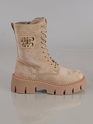 Der OFF#DLY Boot BB Suede beige zeigt einen modischen, taupefarbenen Schnürstiefel mit robuster Profilsohle, runden Zehen, Metallösen und dekorativem BB-Logo an der Außenseite nahe dem Knöchel.