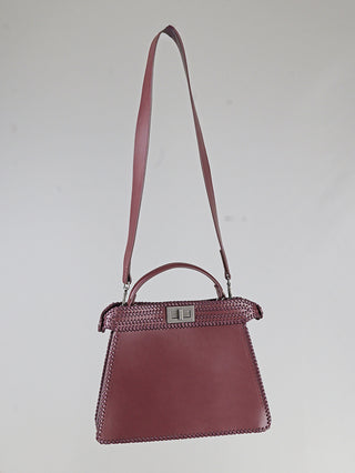 Die OFF#DLY Bag braun ist eine trapezförmige Damenhandtasche mit Peitschennähten, kurzem Griff, langem Schulterriemen und rechteckigem Drehverschluss. Maße: 33 x 25 x 8 cm.