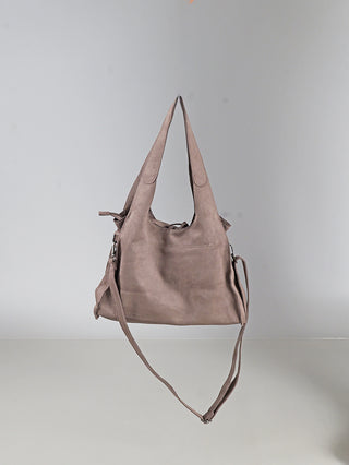 OFF#DLY Shoulder Bag taupe: Slouchy Henkeltasche aus weichem, wildlederartigem Material mit zwei breiten Schulterriemen, Front-Reißverschlusstasche und langem, verstellbarem Crossbody-Riemen, vor neutralem Hintergrund schwebend.