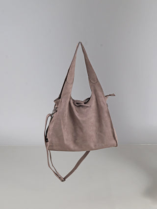 OFF#DLY Shoulder Bag taupe in Velour-Optik, weiche Wildleder-Henkeltasche mit Knotenverschluss und abnehmbarem, verstellbarem Langriemen, schwebend vor neutralem Hintergrund.