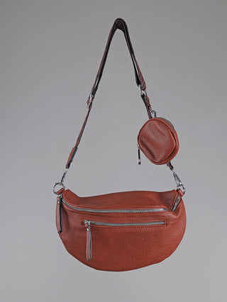 OFF#DLY Crossbody Bag zimt: Rötlich-braune Schultertasche aus Polyurethan mit verstellbarem Gurt, silbernen Beschlägen, Hauptfach, Fronttasche und kleinem, runden Münzbeutel am Gurt. Größe: 30x17 cm.