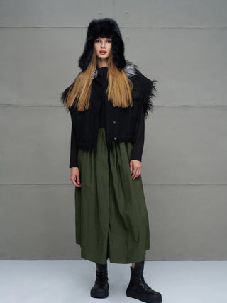 Das Bild zeigt ein Model mit dem #VDR Pan Hat black, einem schwarzen Trapper-Hut mit Kunstfell und Ohrenschutz, der für Wärme und modischen Stil im Winter sorgt.