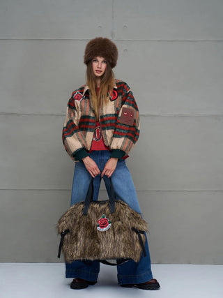 Junge Frau in winterlichem Look hält die #VDR Rambo2 Bag aus braunem Kunstfell mit Rosen-Patch, bietet viel Stauraum, als Schultertasche oder Crossbody tragbar.