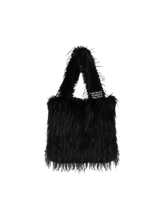 Kleine #VDR Tasche PastelBag black aus langem, zotteligem schwarzem Kunstfell mit kurzen, ebenfalls fellbedeckten Henkeln und einem kleinen gewebten Etikett an der oberen Kante.
