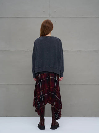 Person von hinten in einem #VDR Sweater 18005 anthrazit mit oversized Schnitt, seitlichen Zipper-Details und Crew Neck, kombiniert mit einem roten Karo-Rock und klobigen, kniehohen Stiefeln.