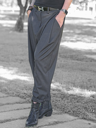 OFF#DLY Baggy Pant Abby anthrazit: Elegante, anthrazitfarbene Hose mit Faltenwurf, lockerem Schnitt und umgeschlagenem Saum, getragen mit schwarzem Gürtel, Lederstiefeln und Armbändern, perfekt für Business-Casual-Looks.
