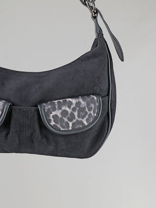 OFF#DLY Bag Leo black: Halbmondförmige Schultertasche aus schwarzem Velourslederimitat mit kurzen Metallkettengliedern und zwei kleinen Klappentaschen mit grauschwarzem Animal-Print vorne.